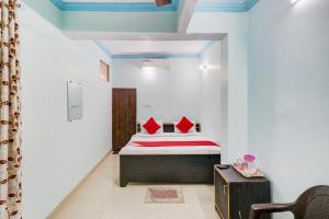 Un dormitorio con una cama con almohadas rojas. en OYO Hotel Shiv Kripa en Kānpur