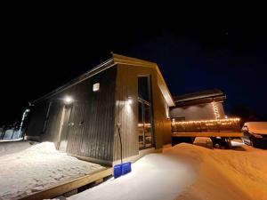 a small building with lights on it in the snow at Moderne leilighet i Alta in Alta