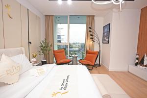a bedroom with a large white bed with orange chairs at Sandy 1BR Soul Beach Mamsha Al Saadiyat Island in Abu Dhabi