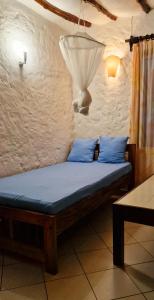 a bed with blue pillows in a room at Frangipani Cottages in Diani Beach