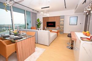 阿布達比的住宿－Sandy 1BR Soul Beach Mamsha Al Saadiyat Island，厨房以及带沙发和桌子的客厅。