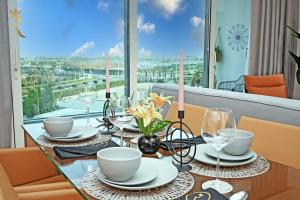 a dining room table with a view of the city at Sandy 1BR Soul Beach Mamsha Al Saadiyat Island in Abu Dhabi