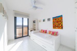 een witte kamer met een bed en een raam bij Casa Minuni in Almería