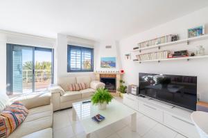 sala de estar con sofá y TV grande en Casa Minuni, en Almería
