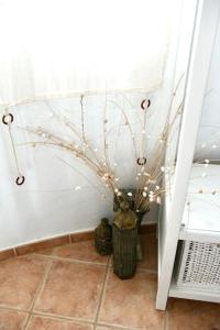 a vase with branches in a room with a window at apartment with magnificient Es Vedra view in Cala Vadella