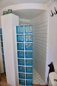 a bathroom with blue glass shelves in a shower at apartment with magnificient Es Vedra view in Cala Vadella