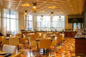 a restaurant with tables and chairs and a bar at Elite Resort & Spa in Manama