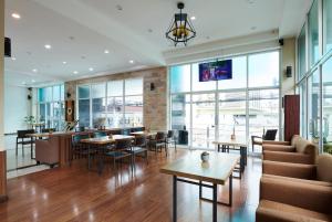 un ristorante con tavoli e sedie e un bar di Adelphi Pattaya - SHA Extra Plus a Centro di Pattaya