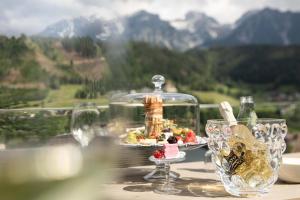 a table with wine glasses and a plate of food at Chalets Coburg in Schladming