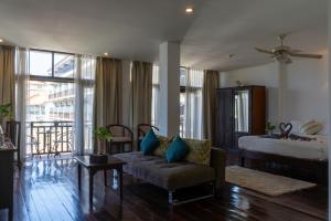 um quarto de hotel com uma cama, um sofá e uma cama em Silver Naga Hotel em Vang Vieng