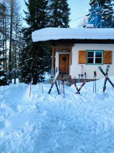 a group of skis in the snow in front of a cabin at Ski in - Ski out am Hauser Kaibling in Haus im Ennstal