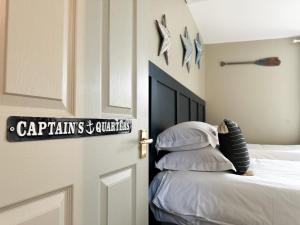 a bedroom with a bed and a door with a sign on it at Harbour Way Cottage by Coast & Country Stays in Seahouses +28 photos
