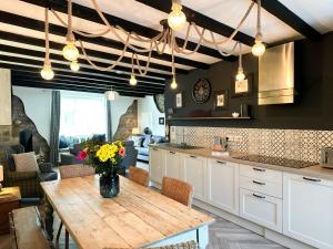 a kitchen with a wooden table with flowers on it at Harbour Way Cottage in Seahouses