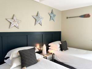 two beds in a room with stars on the wall at Harbour Way Cottage by Coast & Country Stays in Seahouses