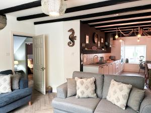 a living room with a couch and a kitchen at Harbour Way Cottage by Coast & Country Stays in Seahouses