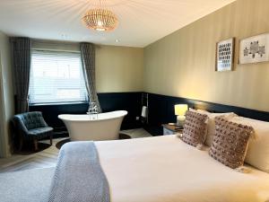 a bedroom with a bed and a bath tub and a bath tub at Harbour Way Cottage by Coast & Country Stays in Seahouses