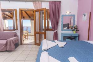 ein Schlafzimmer mit einem blauen Bett und einem Spiegel in der Unterkunft Galini Apartments in Léntas