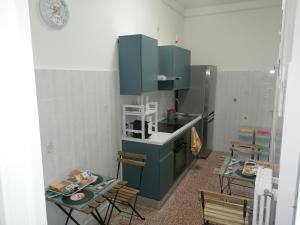 a kitchen with blue cabinets and a table and chairs at A casa di Vito in Matera