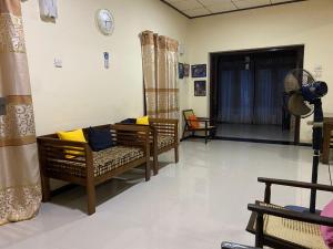 a living room with chairs and a couch and a fan at Serene Garden Lodge in Ahangama