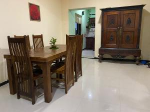 a dining room with a wooden table and chairs at Serene Garden Lodge in Ahangama