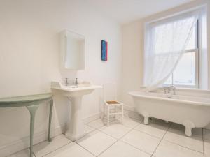 a white bathroom with a sink and a tub and a window at 3 Bed in Keswick SZ030 in Keswick