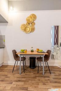 comedor con mesa y sillas en Résidence du Parc appartement calme, en Châtel-Guyon