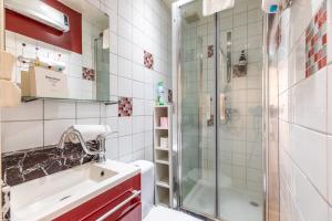 uma casa de banho com um lavatório e um chuveiro em Résidence du Parc appartement calme em Châtel-Guyon