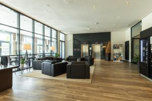 eine Bürolobby mit schwarzen Möbeln und großen Fenstern in der Unterkunft IntercityHotel Dresden in Dresden