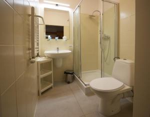 a bathroom with a toilet and a sink and a shower at Hotel Miramar in Sopot