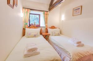 two twin beds in a room with a window at 3 Bed in Borrowdale SZ465 in Rosthwaite