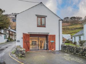 a white house with brown doors on a street at 3 Bed in Borrowdale SZ465 in Rosthwaite