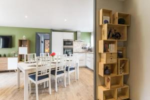uma sala de jantar e cozinha com uma mesa branca e cadeiras em Gîte Un air de Bicoque em Dives-sur-Mer