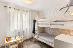 1 Schlafzimmer mit 2 Etagenbetten und einem Schreibtisch in der Unterkunft Gîte Un air de Bicoque in Dives-sur-Mer