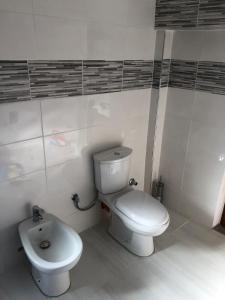 uma casa de banho com um WC branco e um bidé em Villa lake ohrid em Pogradec