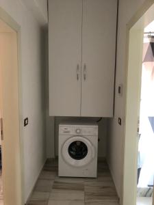 uma lavandaria com uma máquina de lavar roupa e armários em Villa lake ohrid em Pogradec