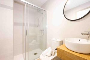 ein weißes Badezimmer mit Waschbecken und Dusche in der Unterkunft Apartamentos turísticos Plaza sevillano , by CartagenaSpain in Cartagena + 31 Fotos