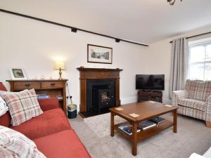 a living room with a red couch and a fireplace at 3 Bed in Newlands Valley SZ075 in Borrowdale