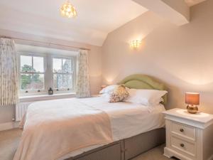 a bedroom with a large bed and two windows at 3 Bed in Dockray SZ138 in Dockray
