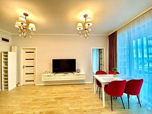 a dining room with a table and red chairs at Summerland Seaview Apartments in Mamaia