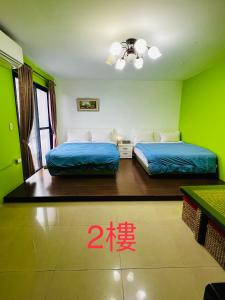 twee bedden in een kamer met groene muren bij Aegean Sea Guest House in Jiufen