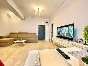 a living room with a couch and a flat screen tv at Summerland Seaview Apartments in Mamaia