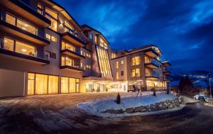 a large building with snow in front of it at Chalets Coburg in Schladming