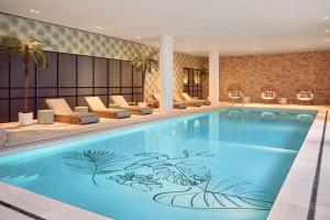 a pool in a hotel with lounge chairs and a pool at Van der Valk Hotel Lelystad in Lelystad