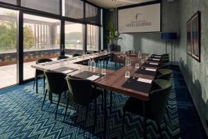 una sala da pranzo con tavoli e sedie lunghi di Van der Valk Hotel Lelystad a Lelystad