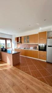 a large kitchen with wooden cabinets and a white refrigerator at Vila Lufi in Kamëz