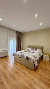 a bedroom with a bed and a wooden floor at Vila Lufi in Kamëz