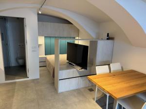 Zimmer mit einem Esstisch und einem TV sowie einem Schlafzimmer. in der Unterkunft Gloria Holiday - Kranjska Gora Apartments in Kranjska Gora