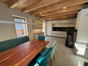 ein Esszimmer mit einem Holztisch und grünen Stühlen in der Unterkunft Gloria Holiday - Kranjska Gora Apartments in Kranjska Gora