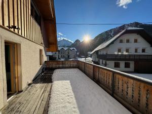 einen Balkon mit einer Holzterrasse mit Bergblick in der Unterkunft Gloria Holiday - Kranjska Gora Apartments in Kranjska Gora