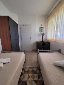 a room with two beds and a cabinet and a door at Apartment Toth - Rtina Benići in Rtina